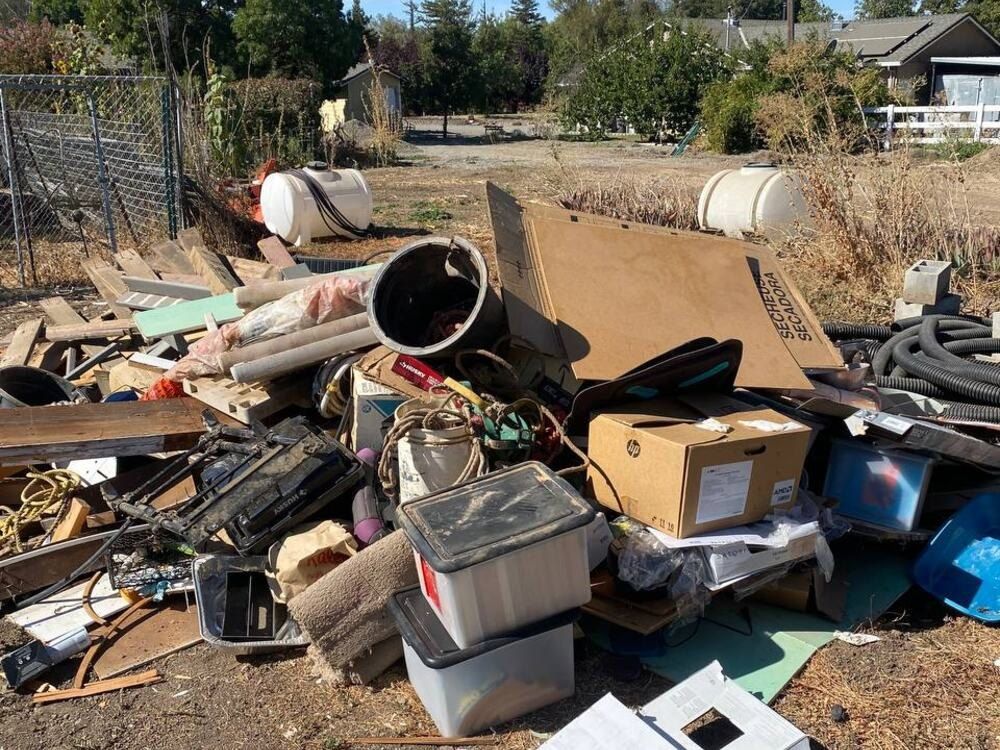 Before: scrap lumber, cans, cardboard and household junk piled on a dirt lot