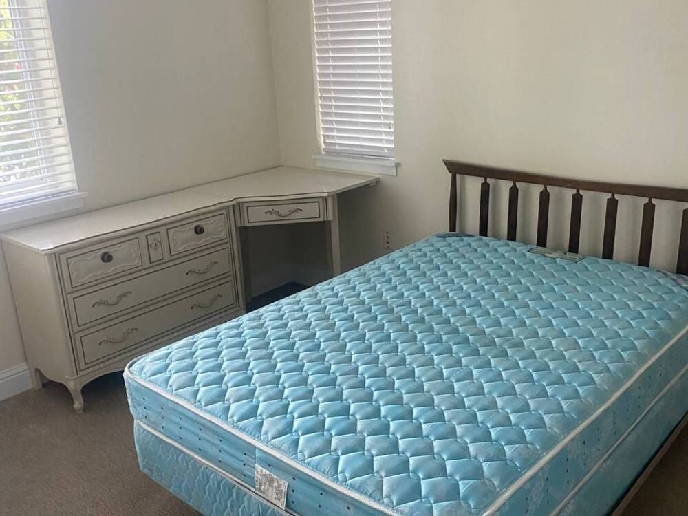 Before: a bedroom with a bare mattress, bed frame and dresser
