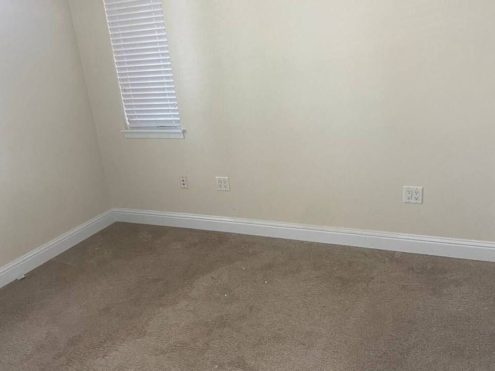 After: the same bedroom empty and vacuumed