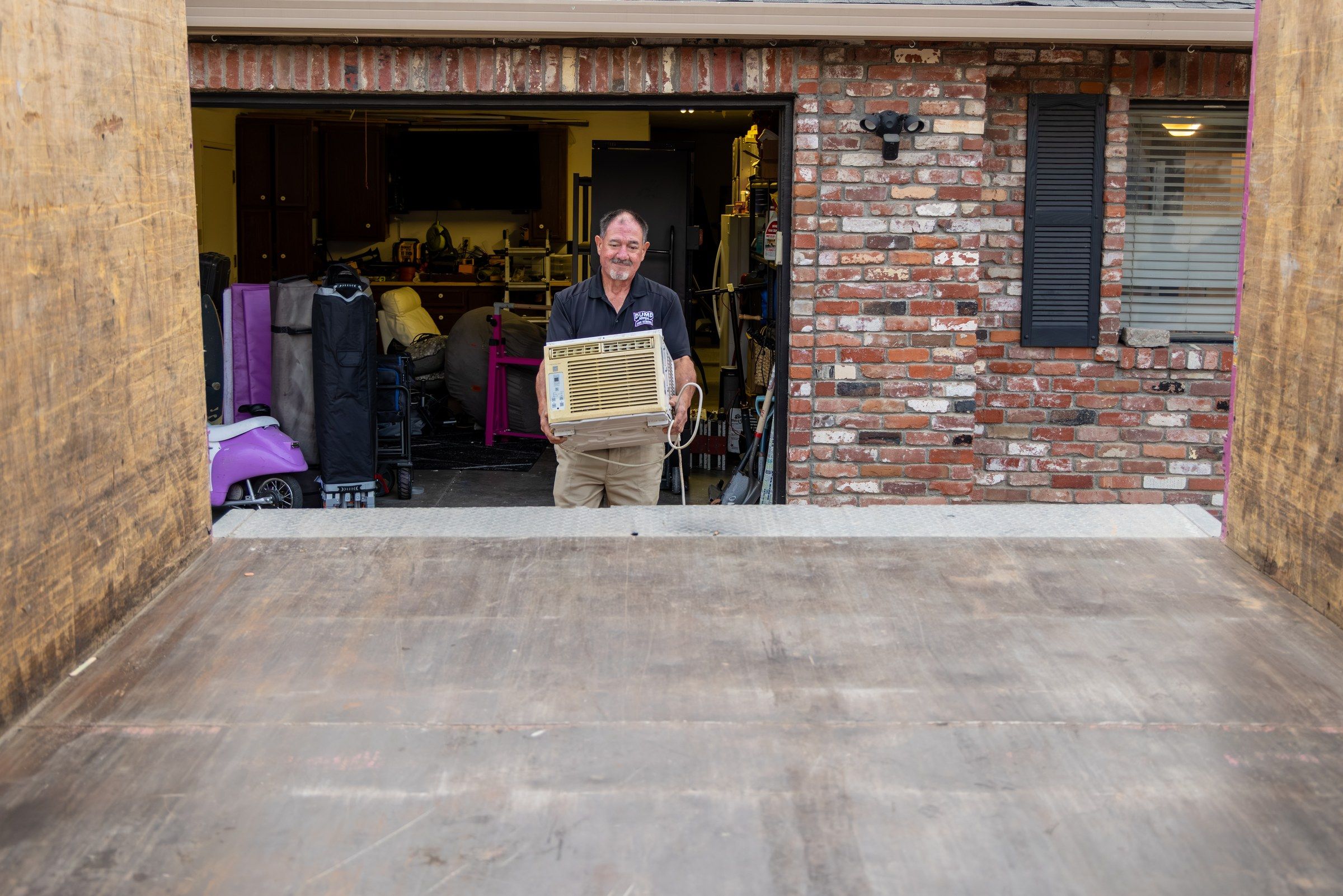 An emptied and swept two-car garage in Woodland after a Dump Ninja cleanout, crew member standing in the doorway